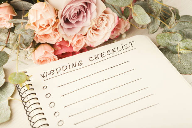 Wedding checklist with copy space adn rose bouquet on the white desktop.